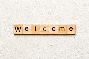 WELCOME word written on wood block. WELCOME text on table, concept