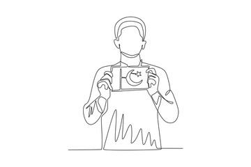 A man holding a picture of a Pakistani flag