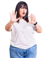 Young plus size woman wearing casual clothes doing stop gesture with hands palms, angry and frustration expression