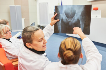 Professionals in audience examining medical x-ray at conference