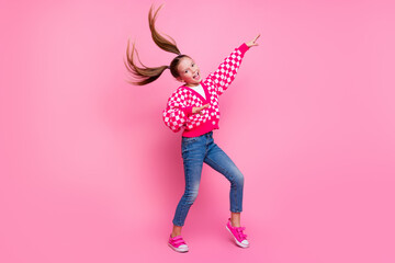 Full size photo of nice lovely schoolgirl with fluttering tails dressed knit cardigan jeans dancing isolated on pink color background