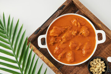 Tasty butter chicken curry dish from Indian cuisine. Tasty butter chicken curry, Murg Makhanwala or masala. Butter chicken tikka masala served with roti / Paratha and plain rice along with onion salad