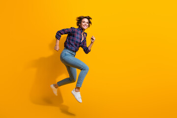 Fototapeta na wymiar Full size photo of active optimistic nice girl wear checkered blouse hurry running to empty space isolated on yellow color background