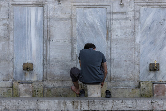 Istanbul, Turkey - 23 April 2023: View of devote persons washing the feet before the praying at Suleymaniye Mosque, Istanbul, Turkey.