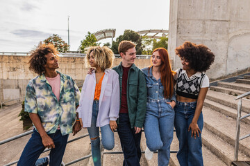 Multiracial young people laughing together - Happy group of friends having fun - Youth community concept with boys and girls hugging outdoors - obrazy, fototapety, plakaty