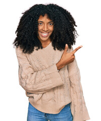 Young african american girl wearing casual clothes cheerful with a smile of face pointing with hand and finger up to the side with happy and natural expression on face