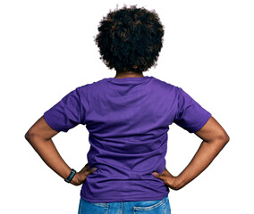 African american woman with afro hair wearing casual purple t shirt standing backwards looking away...