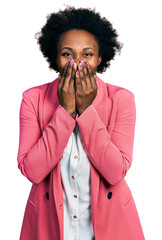 African american woman with afro hair wearing business jacket laughing and embarrassed giggle...