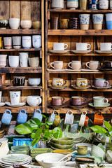 Multitude of handmade pottery shelves in small store.