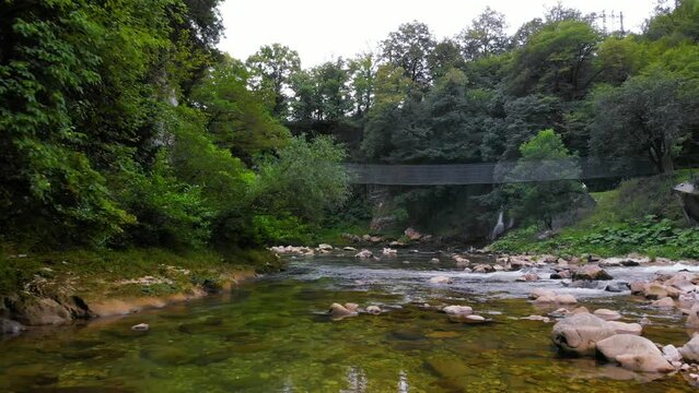 Abhesi waterfall among green trees, a mountain river with clear water. the stones are turned by the stream. Tourist place for rest and swimming. Aerial view. western Georgia Abasha river Martvili