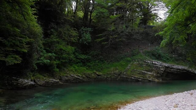 a mountain river with clear water among green trees. the stones are turned by the stream. Tourist place for rest and swimming. Aerial view. western Georgia, Abasha river Martvili