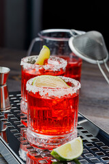 Margarita cocktail with ice, italian style, lime slice and salt rim on a dark board