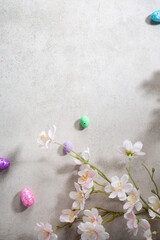 Overhead view of gray concrete surface with spring flowers and eggs