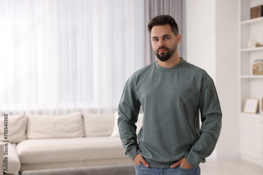 Canvas Prints Handsome man in stylish sweater at home, space for text