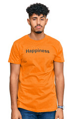 Young arab man wearing tshirt with happiness word message looking sleepy and tired, exhausted for fatigue and hangover, lazy eyes in the morning.