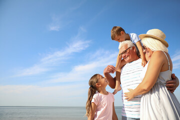 Cute little children with grandparents spending time together near sea - obrazy, fototapety, plakaty