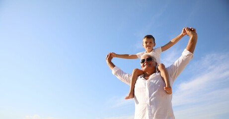 Cute little boy with grandfather spending time together near sea