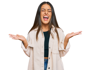 Beautiful hispanic woman wearing casual clothes celebrating mad and crazy for success with arms raised and closed eyes screaming excited. winner concept