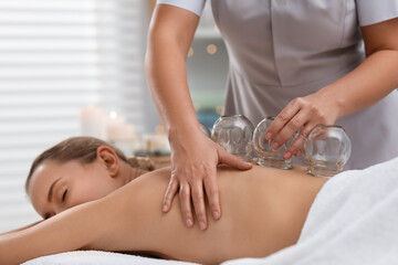 Therapist giving cupping treatment to patient in spa salon