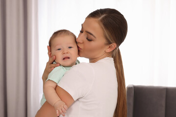 Mother holding her cute newborn baby at home