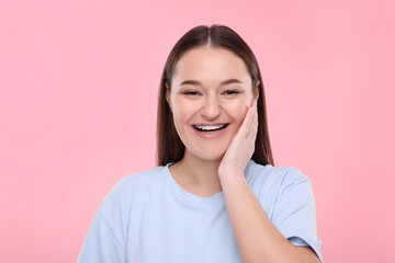 Fototapeta premium Smiling woman with dental braces on pink background