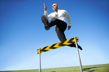 Businessman, hurdle and jumping for career obstacle or competition or employee challenge, growth or...