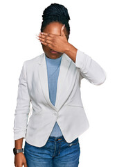 Young african american woman wearing business clothes covering eyes with hand, looking serious and sad. sightless, hiding and rejection concept