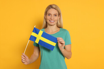 Woman with flag of Sweden on yellow background