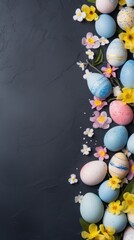 Elegant border of patterned easter eggs and fresh spring flowers on a dark background, space for text