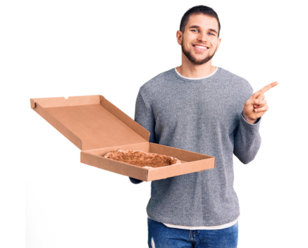 Young handsome man holding delivery italian pizza smiling happy pointing with hand and finger to the side