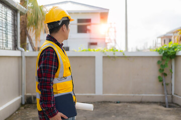 Young man engineer or construction supervisor inspecting work on project, architect wearing helmet and vest doing inspection and inspection. Quality of work done