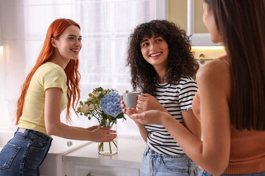 Happy young friends spending time together in kitchen - Powered by Adobe