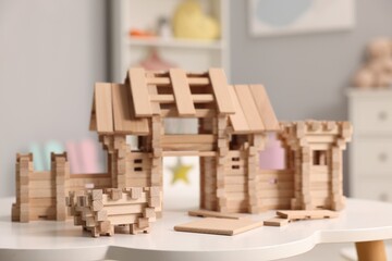 Fototapeta premium Wooden entry gate and building blocks on white table indoors. Children's toy