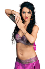 Young indian woman wearing belly dancer costume clueless and confused expression. doubt concept.