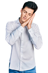 Young hispanic business man wearing business clothes sleeping tired dreaming and posing with hands together while smiling with closed eyes.