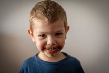 Retrato de niño rubio sonriendo con la boca sucia de chocolate - obrazy, fototapety, plakaty