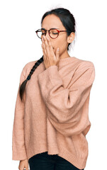 Young hispanic girl wearing casual clothes and glasses bored yawning tired covering mouth with...