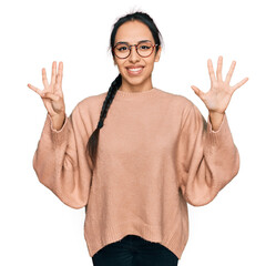 Young hispanic girl wearing casual clothes and glasses showing and pointing up with fingers number...