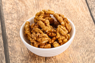 Cracked unshelled walnut in the bowl