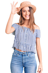 Obraz na płótnie Canvas Young beautiful girl wearing hat and t shirt smiling positive doing ok sign with hand and fingers. successful expression.