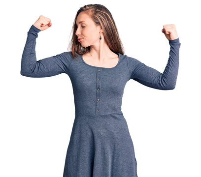 Young beautiful blonde woman wearing casual dress showing arms muscles smiling proud. fitness concept.