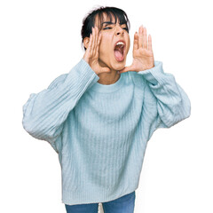 Young hispanic woman wearing casual clothes shouting angry out loud with hands over mouth
