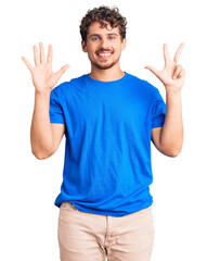 Fototapeta premium Young handsome man with curly hair wearing casual clothes showing and pointing up with fingers number eight while smiling confident and happy.