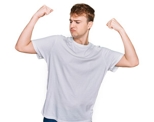 Young caucasian man wearing casual white t shirt showing arms muscles smiling proud. fitness concept.