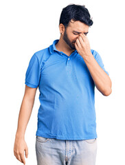 Young hispanic man wearing casual clothes tired rubbing nose and eyes feeling fatigue and headache. stress and frustration concept.