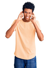 Young african american man wearing casual clothes covering ears with fingers with annoyed expression for the noise of loud music. deaf concept.