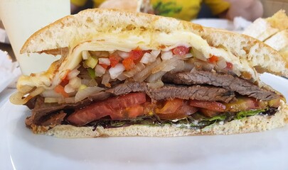 Obraz premium Beirut sandwich (Beirut is a Brazilian sandwich), on a plate in a restaurant, front view. The sandwich was invented in 1950 by two Lebanese brothers, owners of a coffee shop in São Paulo, Brazil.