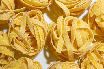 Uncooked Egg-Based Fettuccine Pasta: A Culinary Canvas of Ribbon-Shaped Macaroni, Creating a Lively...