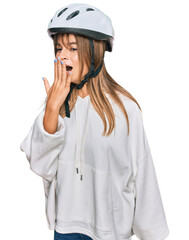 Teenager caucasian girl wearing bike helmet bored yawning tired covering mouth with hand. restless and sleepiness.
