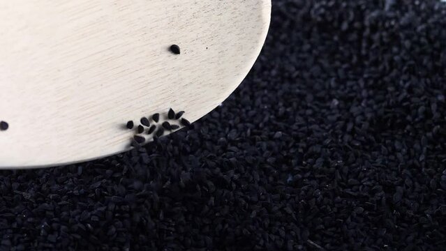 black cumin seeds falling into a heap. slow motion. macro heap black cumin seeds